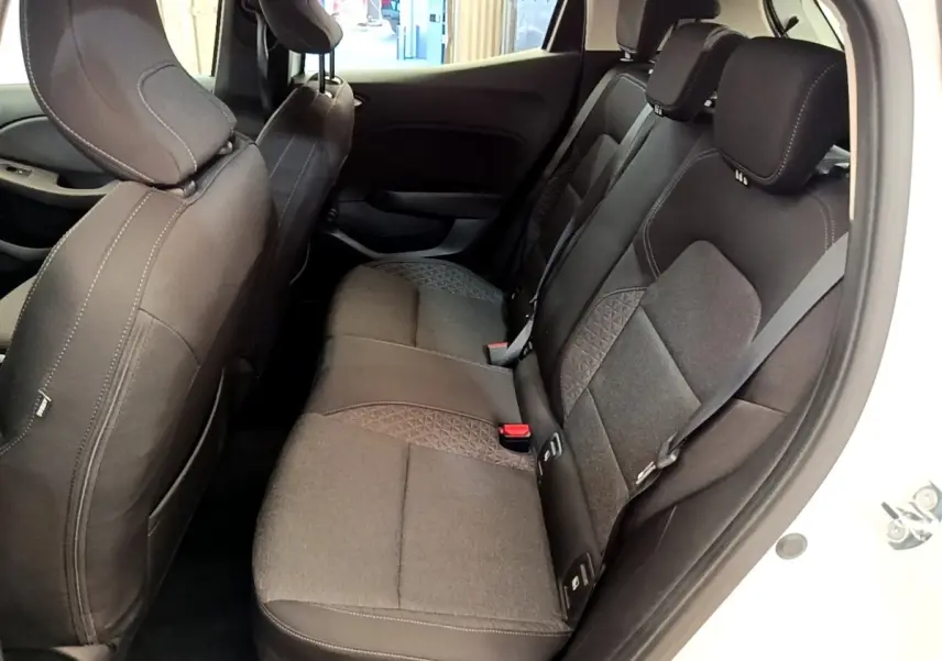 Vue intérieure côté droit montrant la banquette arrière noire avec détails en tissu sur une Renault Clio blanche 2020.