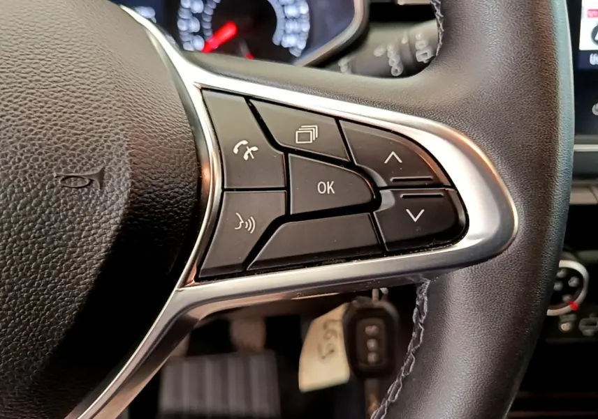 Gros plan sur les commandes multifonctions à droite du volant noir du Renault Clio Business Blue dCi 85 blanc de 2020.