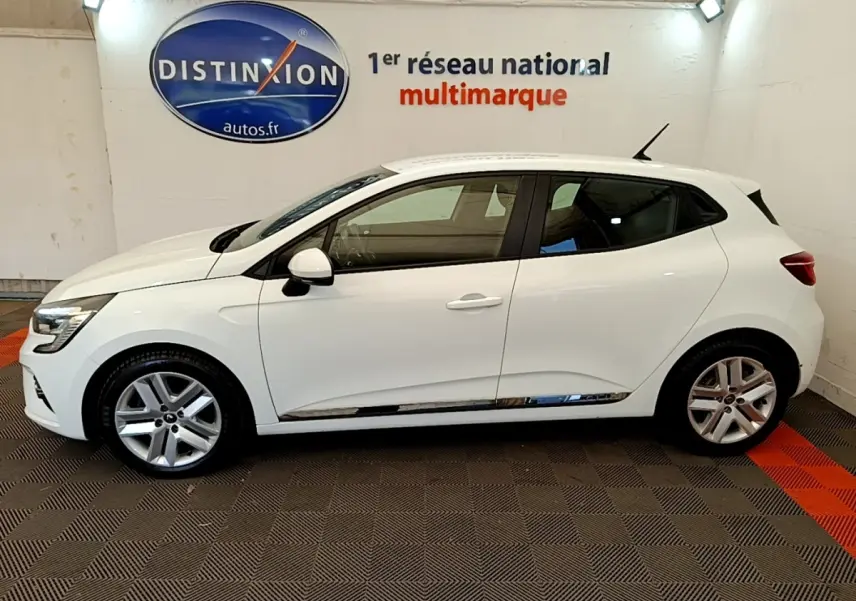 Profil droit d'une Renault Clio Business Blue dCi 85 blanche, en intérieur avec jantes alliage et rétroviseurs blancs.