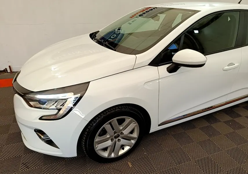 Vue 3/4 avant droit d'une Renault Clio Business Blue dCi 85 blanche avec jantes alliage et feux LED allumés.