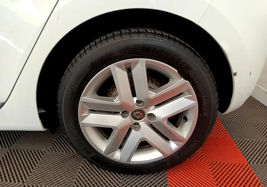 Gros plan sur la roue arrière droite d'une Renault Clio Business Blue dCi 85 blanche avec une rayure visible sur l'aile.