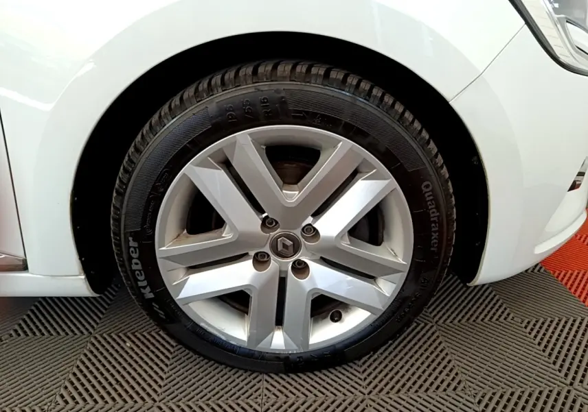 Gros plan sur la roue avant droite d'une Renault Clio Business Blue dCi 85 blanche avec jante alliage siglée Renault.