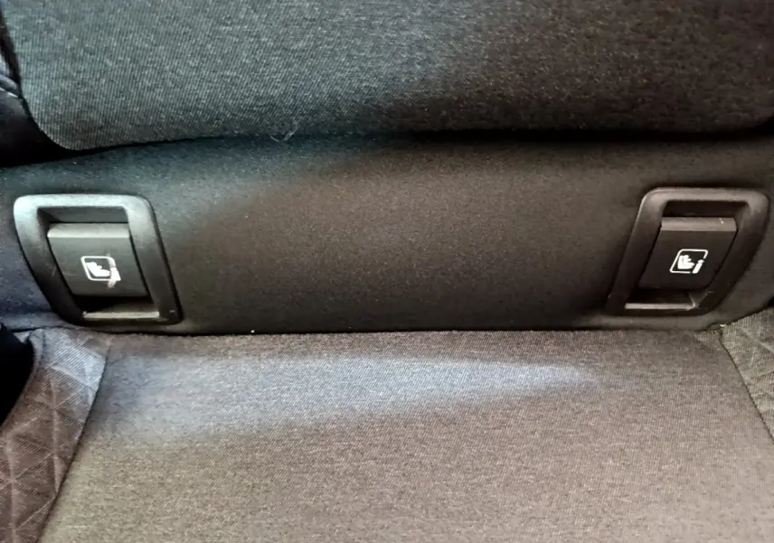 Détail des commandes de rabattement des sièges arrière sur la banquette tissu gris d’une Renault Clio Business Blue dCi 85 blanche.