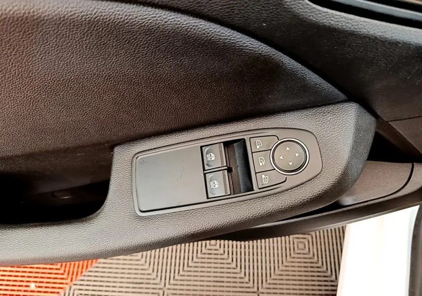 Commande des vitres électriques et réglage des rétroviseurs sur la porte côté conducteur d'une Renault Clio blanche 2020.