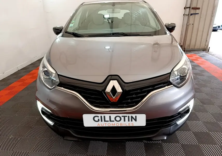 Vue avant d'une Renault Captur Business gris foncé avec phares LED et calandre noire brillante dans un garage.