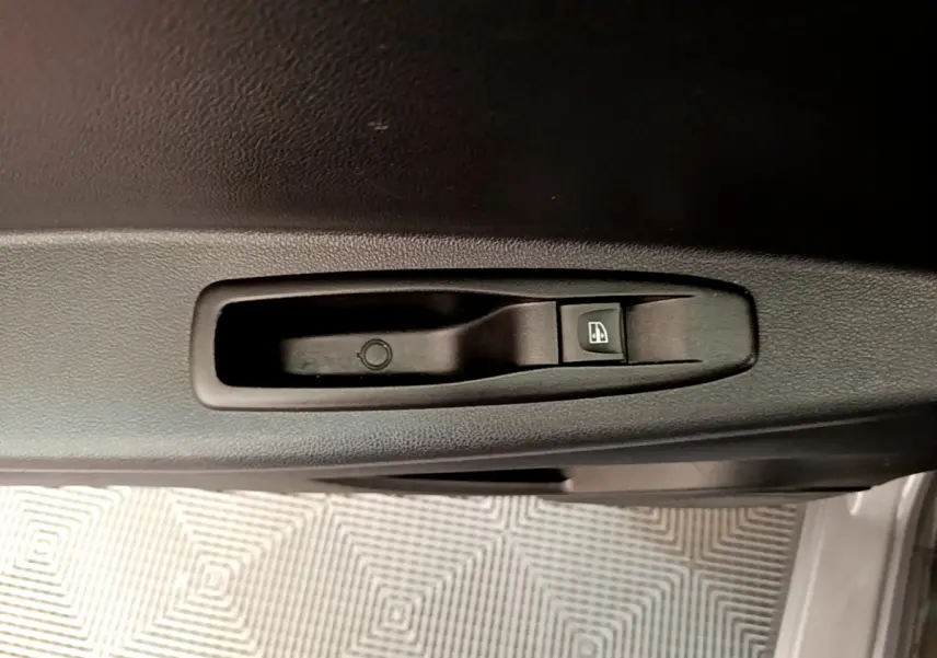 Bouton de commande de lève-vitre côté conducteur sur la porte intérieure noire du Renault Captur gris foncé 2018.