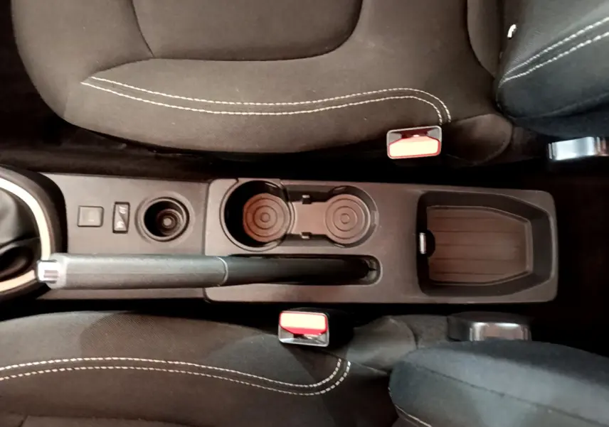 Vue plongeante sur la console centrale noire du Renault Captur gris foncé, avec frein à main et porte-gobelets visibles entre les sièges.