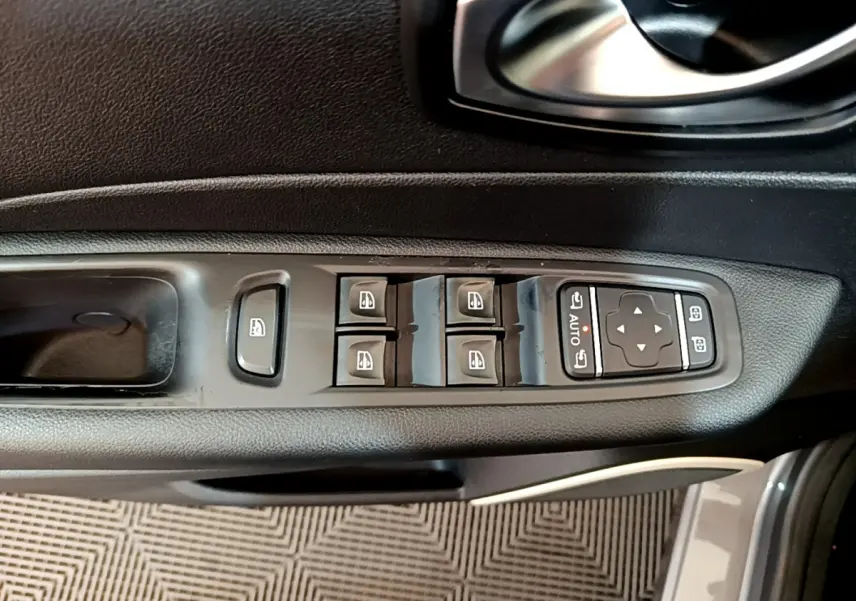 Gros plan sur les commandes des vitres électriques et rétroviseurs côté conducteur d'une Renault Captur gris foncé 2018.