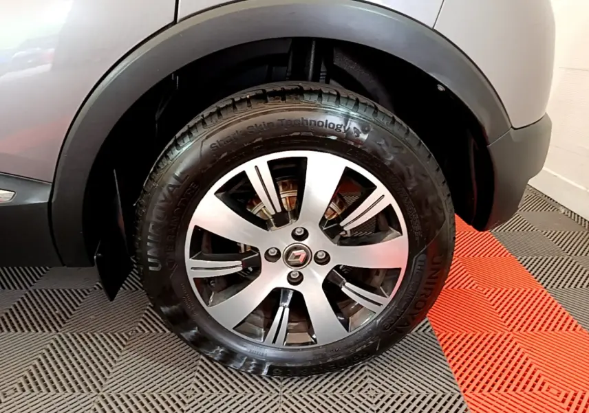 Gros plan sur la roue avant droite du Renault Captur gris foncé, soulignant la jante alliage et le logo central.
