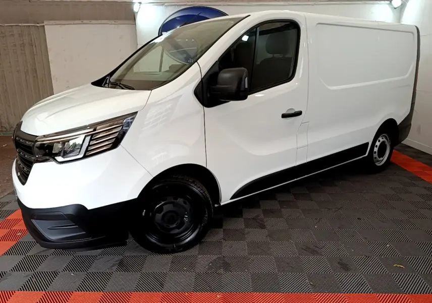 Fourgon blanc Renault Trafic FG CF L1H1 vu de profil côté gauche dans un espace fermé avec sol à motifs noirs et rouges.