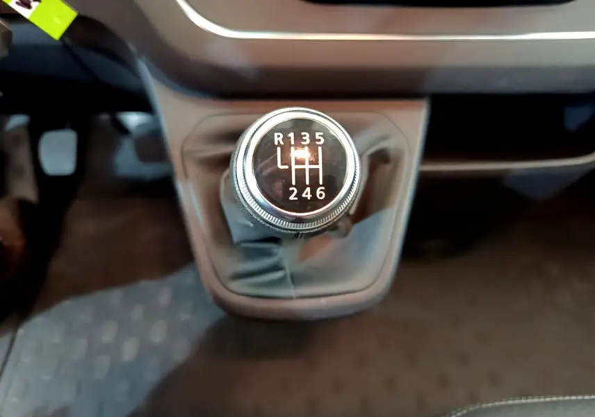 Le levier de vitesses manuel du Renault Trafic Fourgon 2022, vue rapprochée sur la console centrale noire.