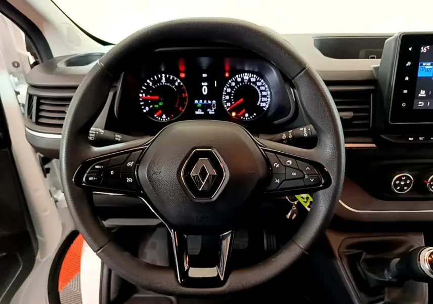 Vue intérieure centrée sur le volant multifonction noir du Renault Trafic Fourgon 2022 avec tableau de bord et levier de vitesse visibles.