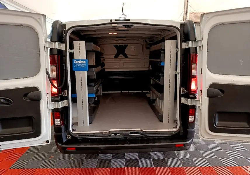 Vue arrière ouverte du Renault Trafic Fourgon blanc 2022 montrant l'intérieur aménagé avec étagères Sortimo SR5.