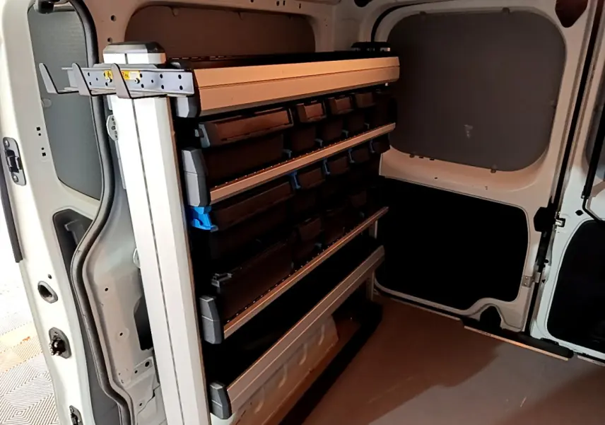 Vue intérieure arrière du fourgon blanc Renault Trafic FG CF L1H1 avec étagères de rangement modulables.