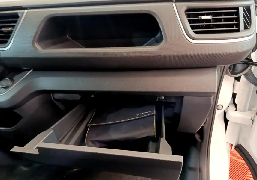 Intérieur du Renault Trafic Fourgon blanc 2022, vue sur la boîte à gants ouverte côté passager avec pochette Renault visible.