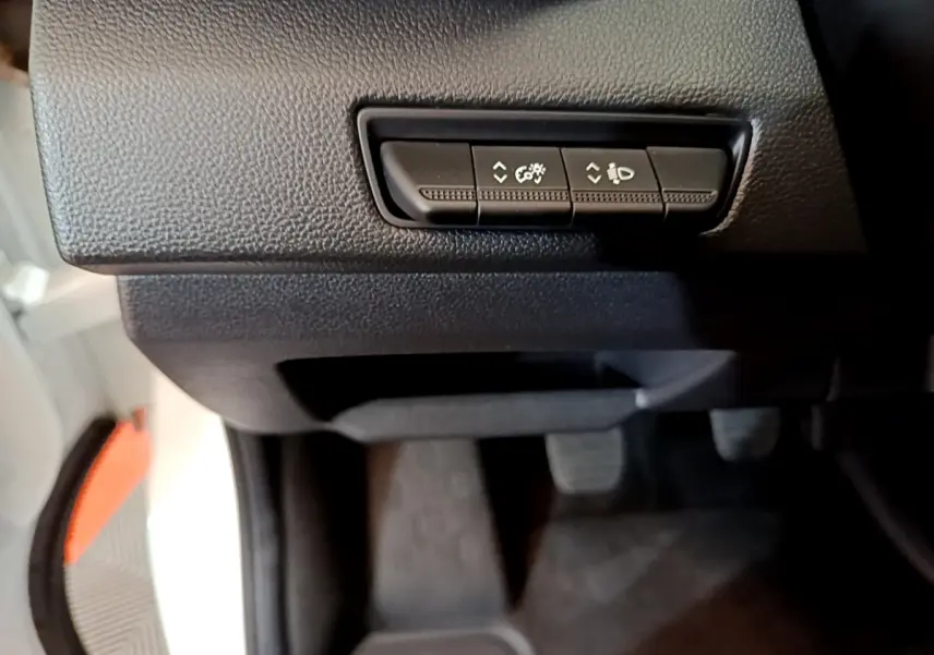 Gros plan sur les commandes de réglage des phares et du tableau de bord du Renault Trafic Fourgon blanc 2022.