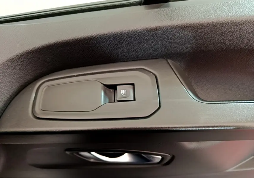Gros plan sur la commande de lève-vitre côté conducteur du Renault Trafic Fourgon blanc 2022.