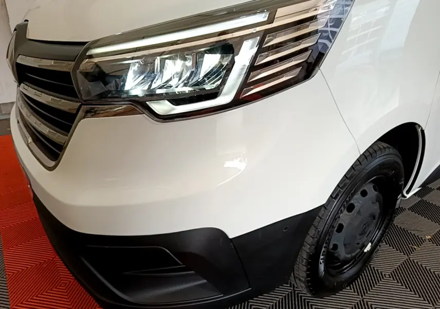 Gros plan sur l'avant droit blanc du Renault Trafic Fourgon 2022, mettant en valeur le phare LED et la calandre noire.