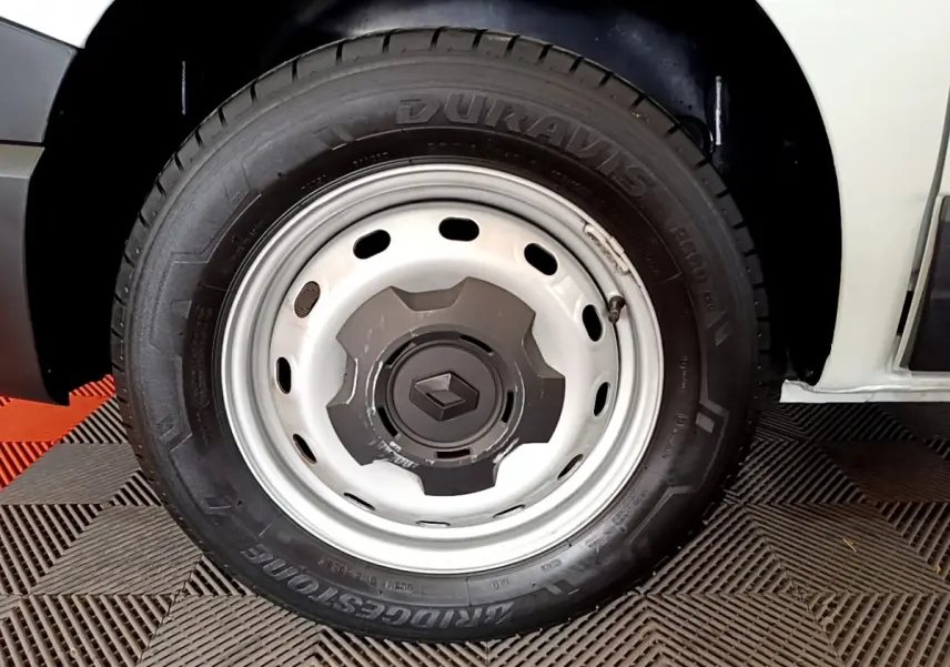 Gros plan sur la roue avant droite blanche du Renault Trafic Fourgon 2022, avec jante acier et logo Renault au centre.