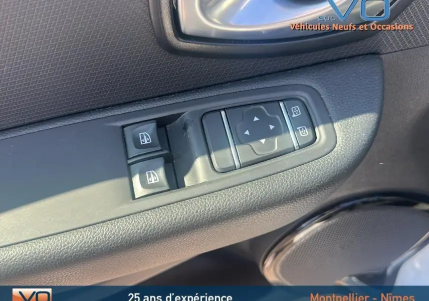 Gros plan sur les commandes électriques des vitres et des rétroviseurs côté conducteur d'une Renault Clio IV Estate Business blanche.