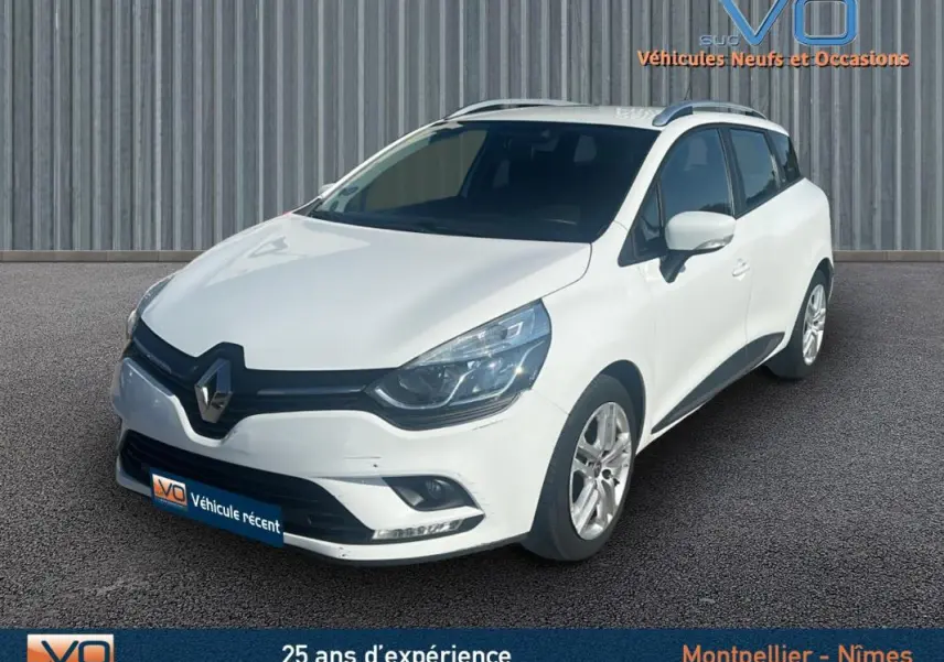 Renault Clio IV Estate Business blanc vue 3/4 avant droit, avec vitres surteintées et jantes alliage visibles.