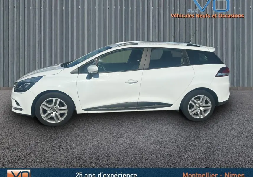 Profil droit d'une Renault Clio IV Estate Business blanche de 2019 avec vitres surteintées et jantes alliage visibles.