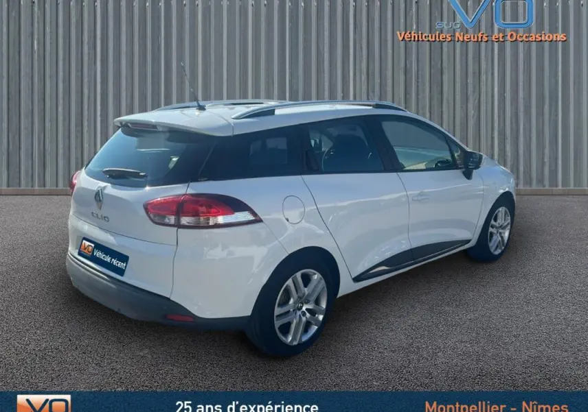 Vue 3/4 arrière droite d'une Renault Clio IV Estate Business blanche avec vitres surteintées et jantes alliage.