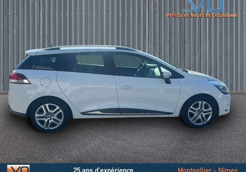 Profil latéral droit d'une Renault Clio IV Estate Business blanche avec vitres surteintées et jantes alliage visibles.