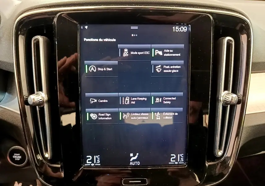 Écran tactile central noir affichant les fonctions du véhicule, entouré de la console brillante du Volvo XC40 noir.