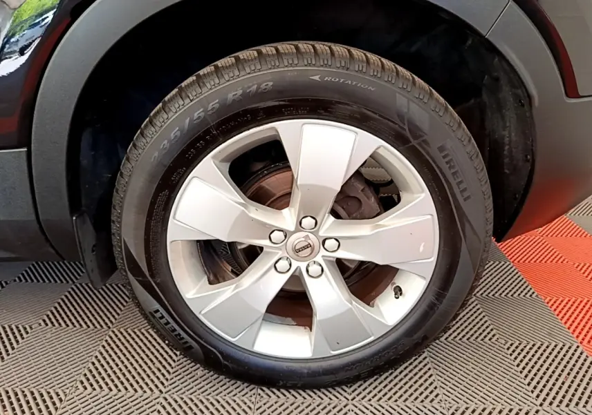 Gros plan sur la roue avant droite d’un Volvo XC40 noir, avec jante alliage argent et pneu Pirelli.