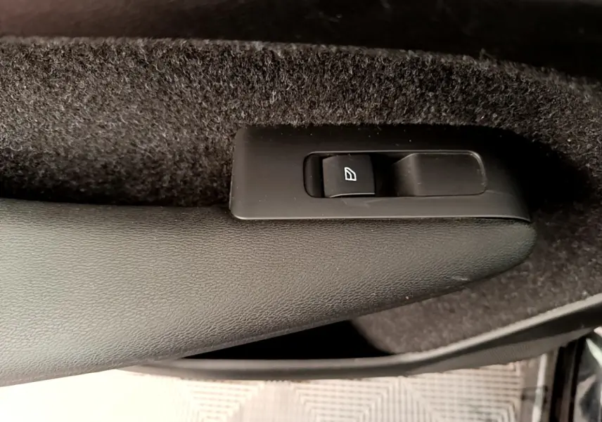 Détail du bouton de commande de lève-vitre sur la porte intérieure côté gauche d’un Volvo XC40 noir.