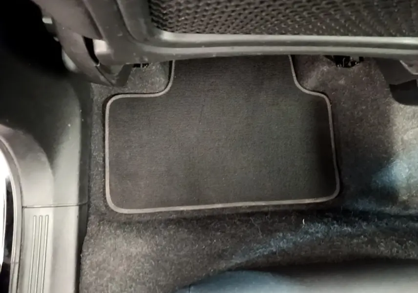 Vue rapprochée du tapis de sol noir côté passager avant du Volvo XC40 T2 2020, intérieur sombre.
