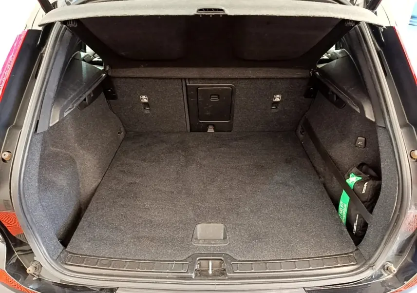 Coffre ouvert vu de l'arrière d'un Volvo XC40 T2 noir, montrant un espace de chargement propre et spacieux.