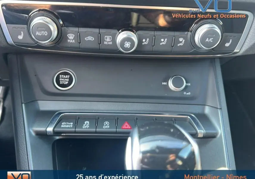 Vue rapprochée de la console centrale noire de l'Audi Q3 Sportback 35 TDI 2020 avec boutons de climatisation et démarrage moteur.