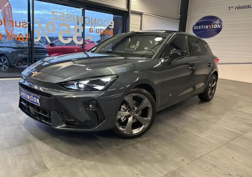 Vue 3/4 avant droite d'une CUPRA Leon gris magnetic avec jantes anthracite et signature lumineuse Tri-LED visible.