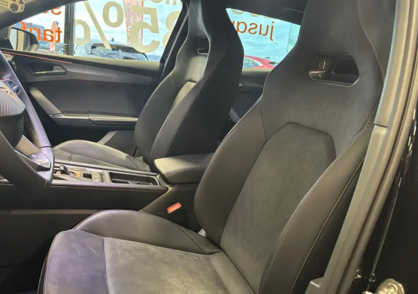 Intérieur côté droit de la CUPRA Leon 2.0 TDI 2026 avec sièges baquets suédine noire et surpiqûres cuivrées.