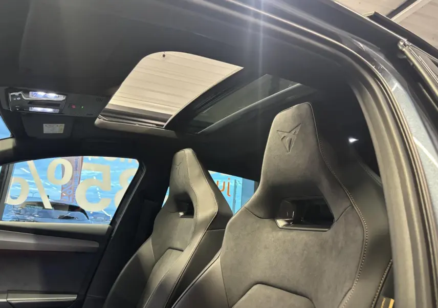 Vue intérieure côté droit des sièges baquets suédine noirs avec surpiqûres cuivrées et toit ouvrant panoramique de la CUPRA Leon gris magnetic.