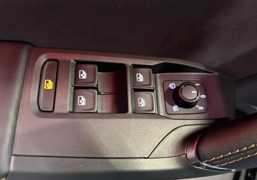 Gros plan sur les commandes de lève-vitres et réglage des rétroviseurs côté conducteur de la CUPRA Leon gris Magnetic.