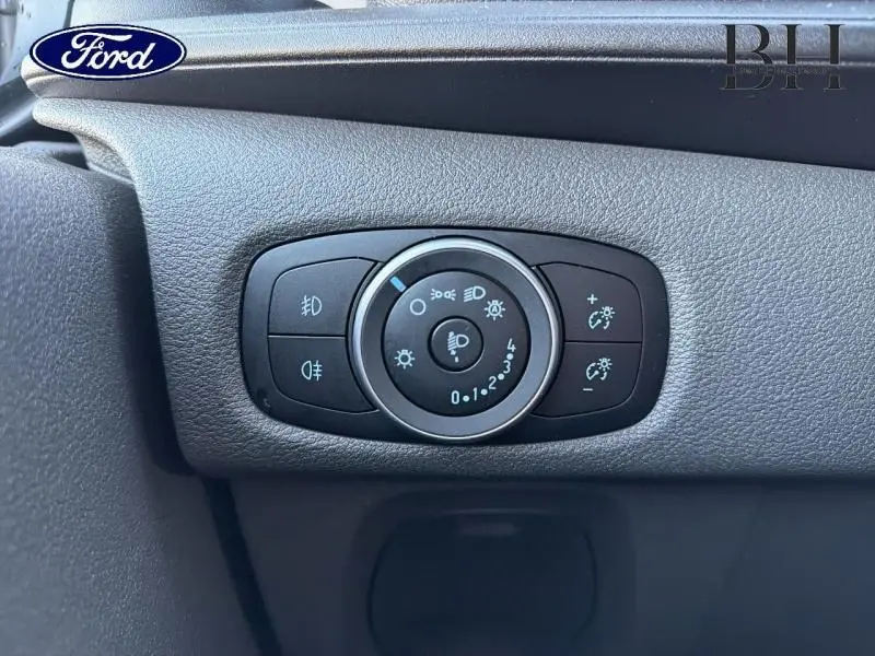 Gros plan sur le panneau de commande des phares noir à l'intérieur du Ford Transit Custom Fourgon 2023.