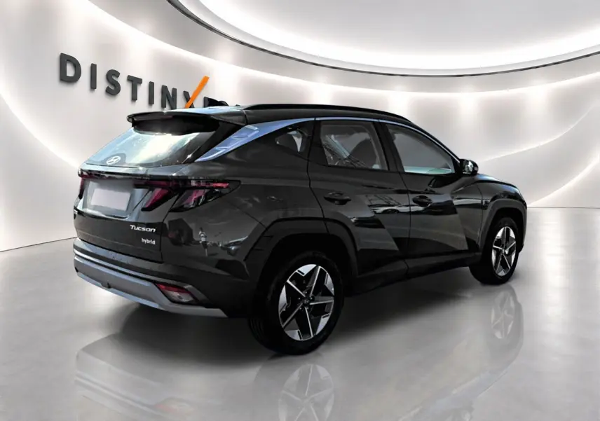 Vue 3/4 arrière droite d'un Hyundai Tucson hybride vert foncé avec jantes alliage et feux arrière LED.
