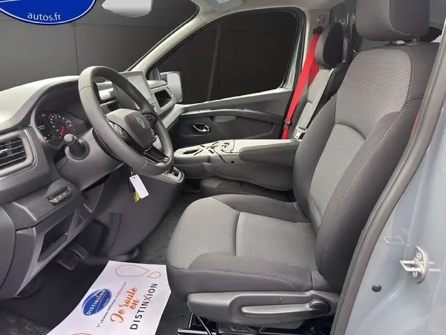 Vue intérieure côté conducteur du Renault Trafic Fourgon gris urbain 2025, avec sièges tissu et volant multifonction.