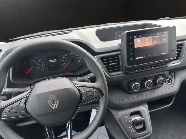 Vue intérieure du tableau de bord du Renault Trafic Fourgon gris urbain, avec volant multifonction et écran tactile central.