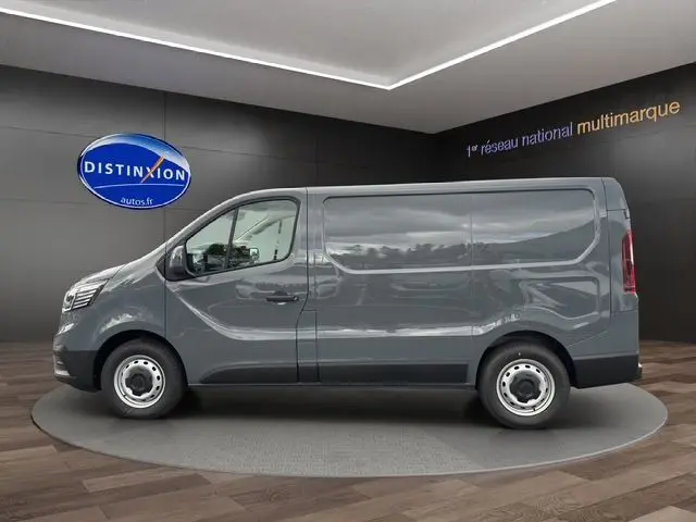 Vue latérale droite d'un Renault Trafic Fourgon gris urbain 2025, avec roues acier et silhouette épurée en showroom.