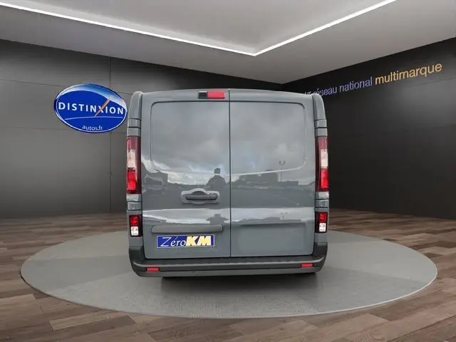 Vue arrière d’un Renault Trafic Fourgon gris urbain 2025, portes battantes fermées avec caméra et radar de recul visibles.