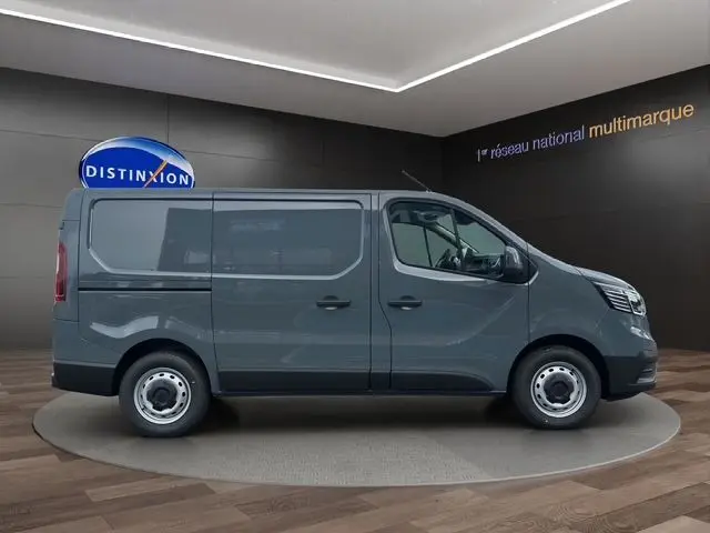 Vue latérale droite du Renault Trafic Fourgon gris urbain 2025, avec roues acier et porte coulissante visible.