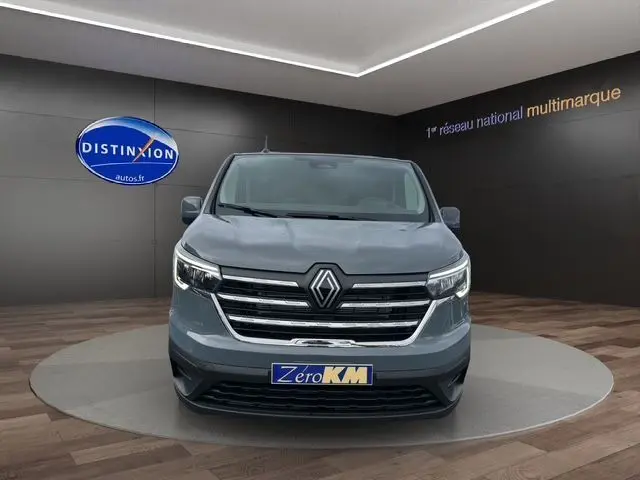 Vue de face du Renault Trafic Fourgon gris urbain 2025 avec calandre chromée et logo central distinctif.