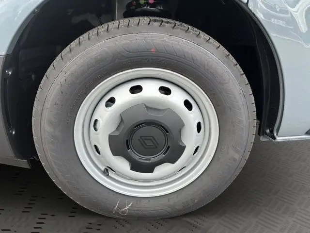 Gros plan sur la roue avant gauche du Renault Trafic Fourgon gris urbain, avec jante acier et logo Renault central.