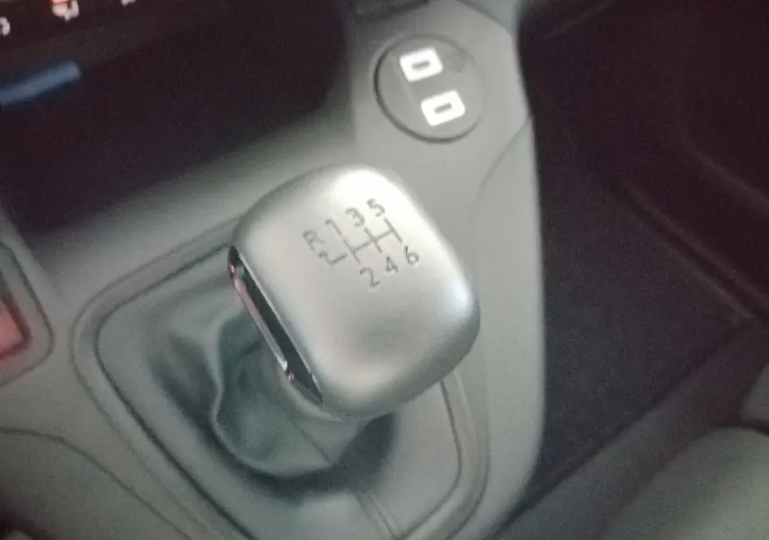 Gros plan sur le levier de vitesses manuel gris du Peugeot Partner FGN 2025, entouré de la console centrale noire.
