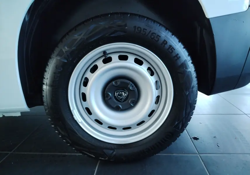 Gros plan sur la roue avant droite du Peugeot Partner FGN blanc Icy, avec jante acier et pneu Continental 195/65 R15.