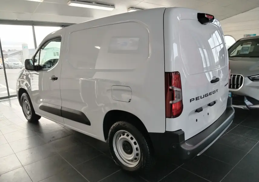 Vue 3/4 arrière droite d’un utilitaire Peugeot Partner FGN blanc Icy, avec porte latérale pleine et feux arrière verticaux.